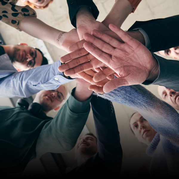 Hands stacked in a team unity gesture